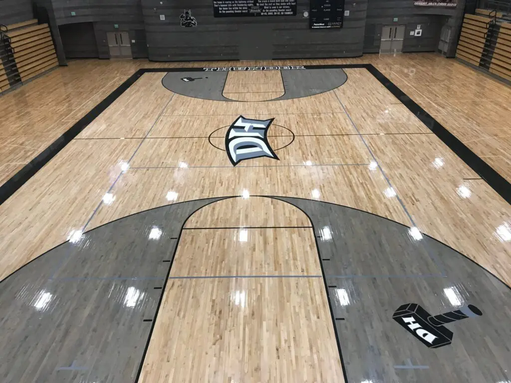 Elevated view of a finished maple court with grey painted keys and a DH logo at center